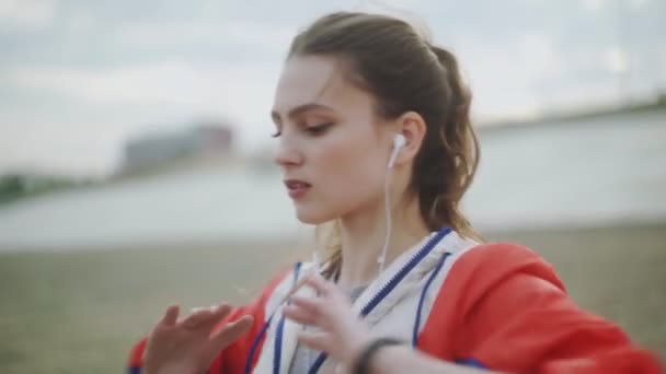 Zdrowa piękna młoda sportowiec kobieta w sportowej odzieży rozciągając ramiona i ciało, aby przygotować się do biegania na ulicy w miejskim parku miejskim — Wideo stockowe