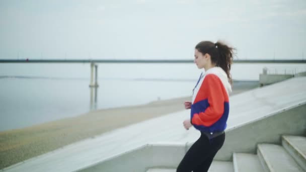 Bella donna in forma indossando vestiti sportivi correre al piano di sotto jogging strada — Video Stock