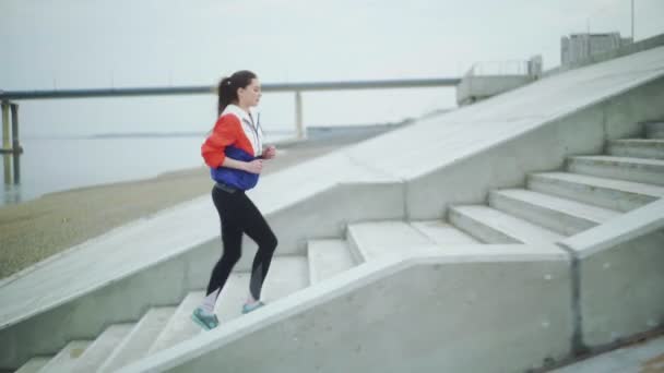 Junge sportliche Frau läuft Treppe hinauf. — Stockvideo