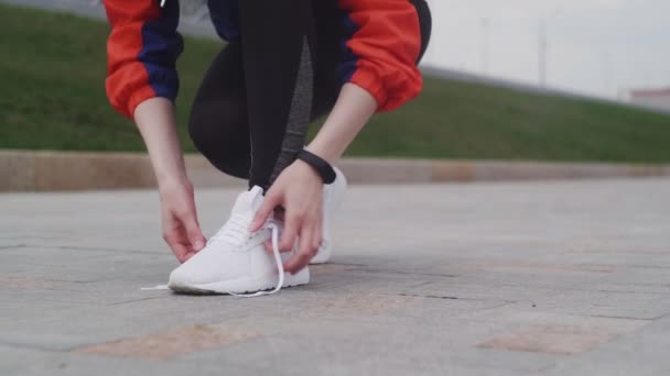 Jeune sportive femelle attachant chaussures dentelle et strating running — Video