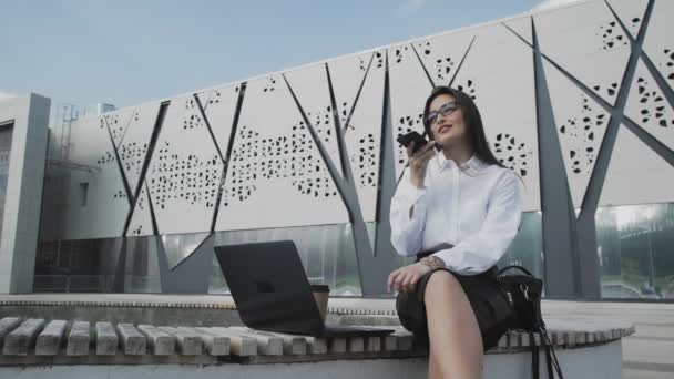 Donna sta registrando il messaggio vocale mentre seduto nel parco con il suo notebook — Video Stock