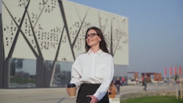 Üzletasszony sétál a belvárosban, hivatásos női munkáltató találkozik a kávéval útközben. — Stock videók
