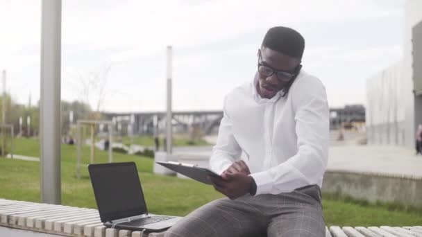 Hombre afroamericano disfrutando de delicioso almuerzo en el parque de la ciudad — Vídeo de stock