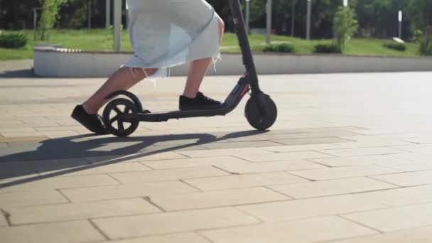 Młoda kobieta kierowca skutera elektrycznego w parku miejskim. transport ekologiczny. — Wideo stockowe