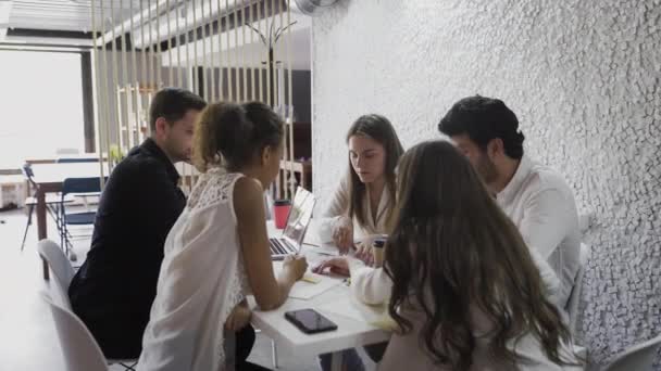 Equipo de jóvenes diseñadores teniendo una reunión en la oficina creativa. Debate empresarial — Vídeo de stock