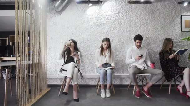 Grupo de candidatos sem emprego sentado em fila à espera de entrevista de emprego — Vídeo de Stock