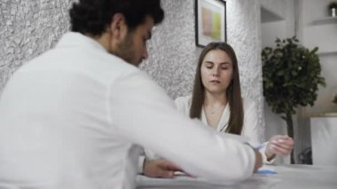 İki iş arkadaşı modern ofiste raporları tartışıyor..