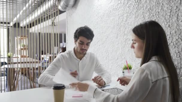Giovani esperti stanno lavorando e parlando a tavola in azienda leader al chiuso. — Video Stock