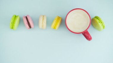 Makaronlar ya da pastel mavi yüzey üzerinde kırmızı bardakta kahve ile makarna..