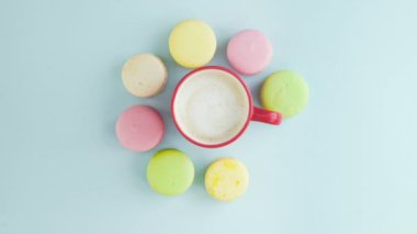 Makaronlar ya da pastel mavi yüzey üzerinde kırmızı bardakta kahve ile makarna..