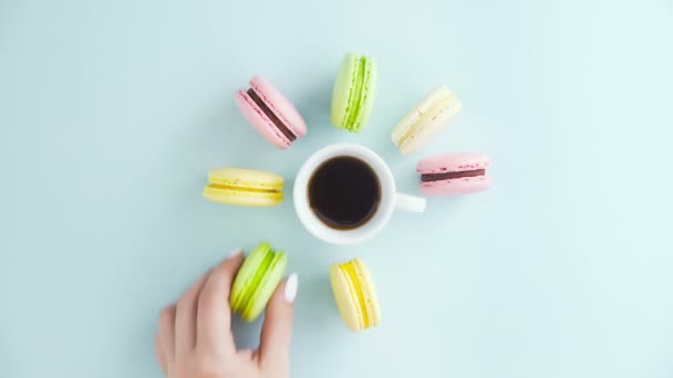 Macarrones o macarones en superficie azul pastel con espresso en taza blanca. — Vídeo de stock