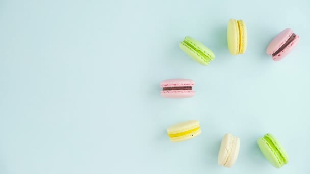 Makronen oder Macaron auf pastellblauer Oberfläche mit Kaffee in roter Tasse. — Stockvideo