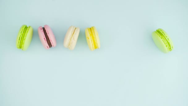 Macarrones o macarones en superficie azul pastel con espresso en taza blanca. — Vídeos de Stock