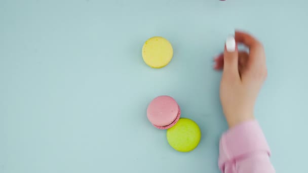 Macarons ou macarons sur une surface bleu pastel avec café en tasse rouge. — Video