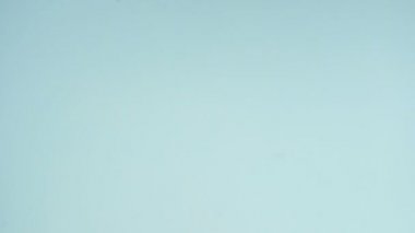 Pembe makaronlar ya da pastel mavi yüzeyde makarna. Kapat..