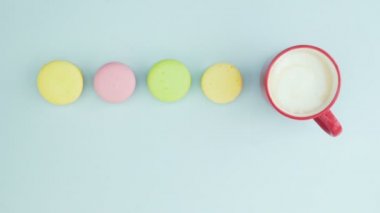 Makaronlar ya da pastel mavi yüzey üzerinde kırmızı bardakta kahve ile makarna..