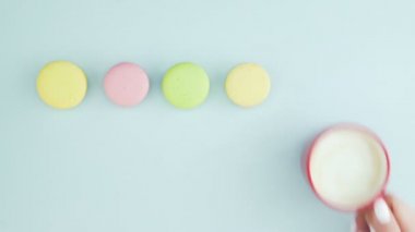 Makaronlar ya da pastel mavi yüzey üzerinde kırmızı bardakta kahve ile makarna..
