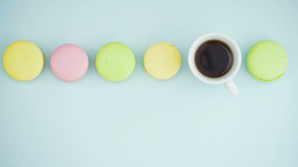 Makronen oder Macaron auf pastellblauer Oberfläche mit Espresso in weißer Tasse. — Stockvideo