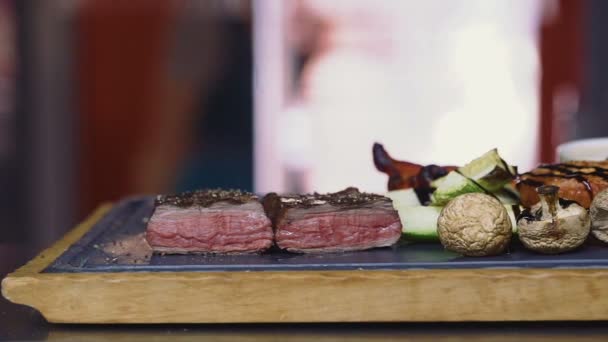 Medium rauw vlees gegrilde barbecue steak met gegrilde groenten — Stockvideo