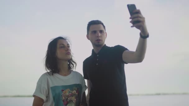 Χαρούμενο ζευγάρι που παίρνει selfie φωτογραφία εξωτερική. — Αρχείο Βίντεο