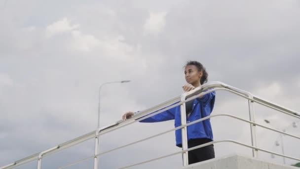 Corredor afro-americano mujer en chaqueta azul terminando running — Vídeos de Stock