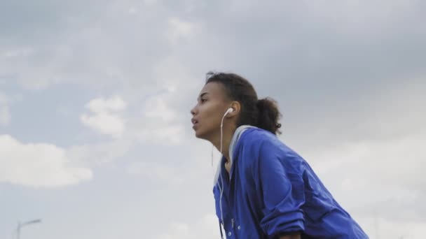 Mujer corredora afroamericana descansando exhausta después de intenso entrenamiento de running entrenamiento cardio atlético mujer deportista en la ciudad — Vídeos de Stock