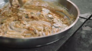 Closeup karıştırma mantar, et, deniz ürünleri ve tereyağı bir kızartma wok tava