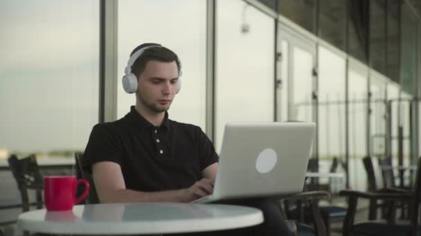 Attraktiv man tidigt på morgonen på ett café, pratar online via surfplatta, dricker kaffe — Stockvideo