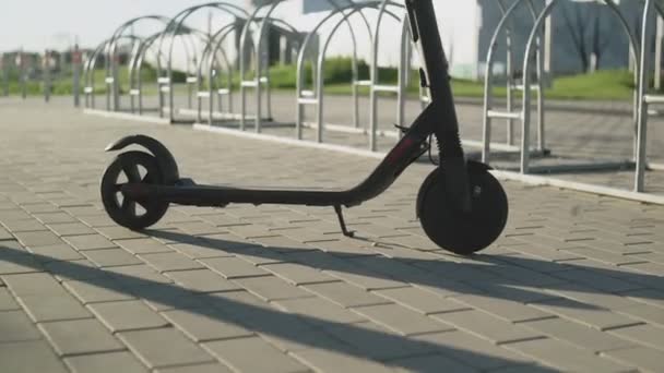 Человек начинает ездить на электрическом скутере в парке — стоковое видео