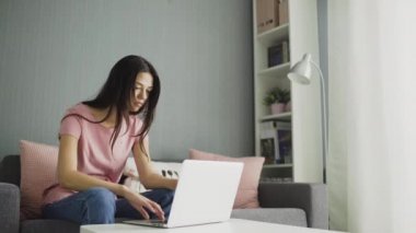 Evde dizüstü bilgisayarla çalışan yorgun bir kadın.