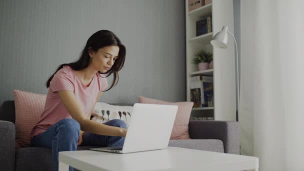 Jonge vrouw klaar met werken op een laptop en vertrekt — Stockvideo