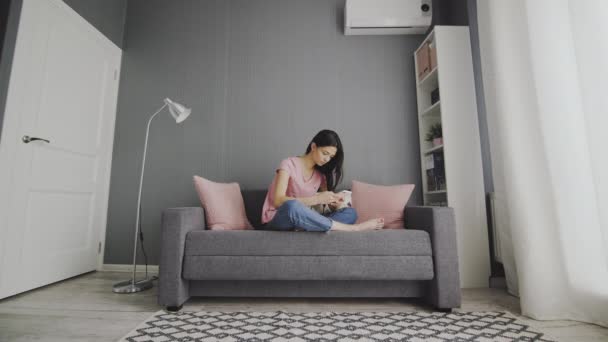 Wanita meninggalkan smartphone dan bersantai duduk di sofa — Stok Video