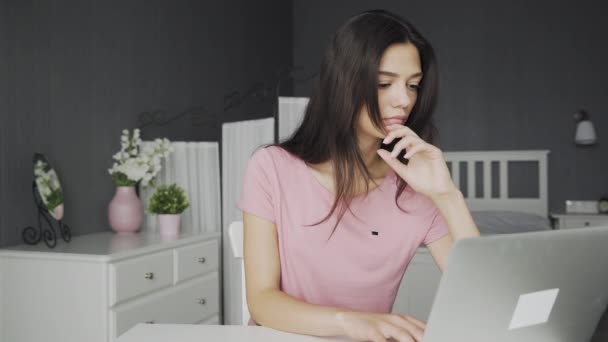 年轻迷人而无聊的女人在家里的卧室里用笔记本电脑工作 — 图库视频影像