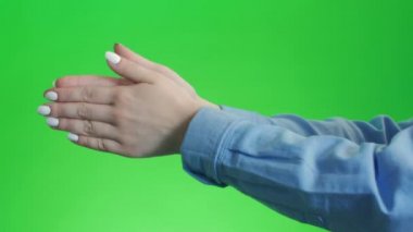 Yapan kız ellerini yeşil ekranda çırpıyor.