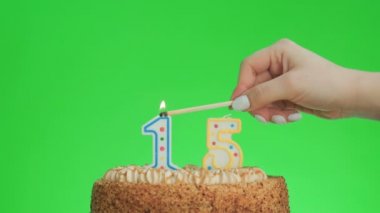 On beş numaralı doğum günü mumunu lezzetli bir pastaya koyuyorum, yeşil ekran 15.
