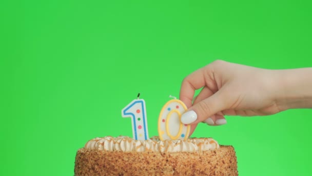 On numaralı doğum günü mumunu lezzetli bir pastaya koyuyorum, yeşil ekran 10. — Stok video