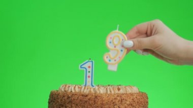 On dokuz numaralı doğum günü mumunu lezzetli bir pastaya koyuyorum, yeşil ekran 19.