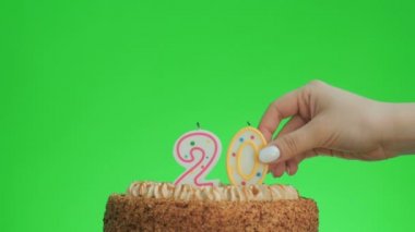 20 numaralı doğum günü mumunu lezzetli bir pastaya koyuyorum, yeşil ekran 20.