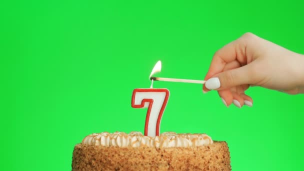 Encendiendo una vela de cumpleaños número siete en un delicioso pastel, pantalla verde 7 — Vídeos de Stock