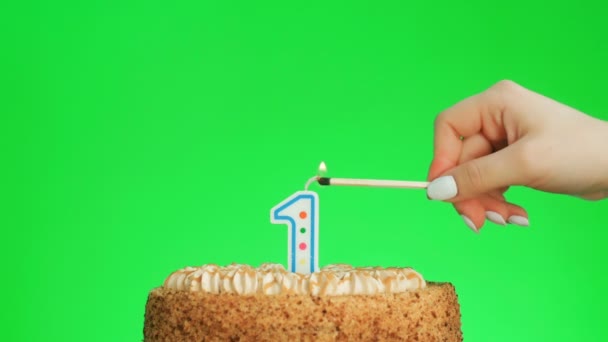 Encendiendo una vela de cumpleaños número uno en un delicioso pastel, pantalla verde 1 — Vídeo de stock