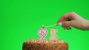 Lezzetli bir pastada 25 numaralı doğum günü mumunu yakıyorum, yeşil ekran 25.