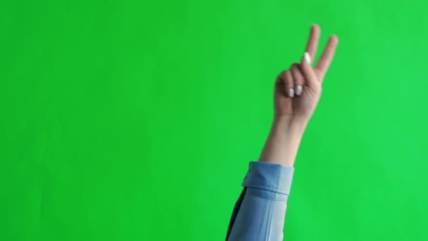 Frauenhand zeigt eine Geste des Friedens. Green Screen Studio — Stockvideo