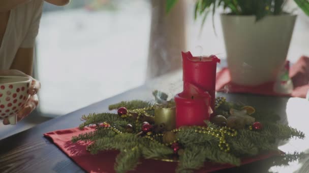Νεαρή γυναίκα σβήνει χριστουγεννιάτικα κεριά. Κλασική Πρωτοχρονιά ή χριστουγεννιάτικα διακοσμητικά — Αρχείο Βίντεο