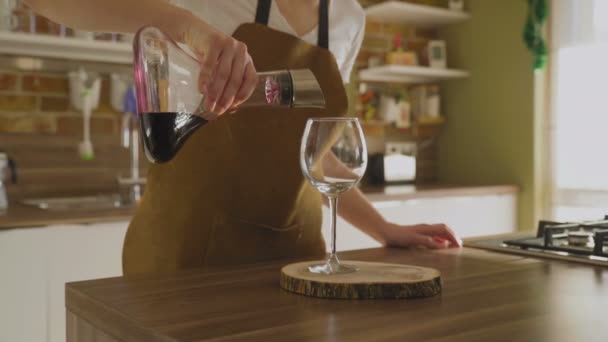 Женщина наливает бокал красного вина в роскошный дом — стоковое видео