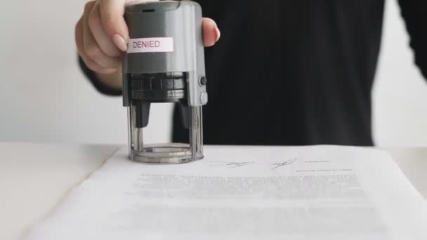 Vrouwelijke hand die een ontkend stempel in het contract of de documenten zet. — Stockvideo