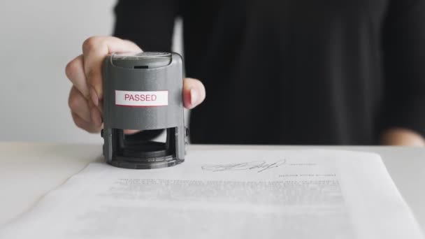 Close up of Female hand that puts an PASSED stamp in the contract or documents. — Stock Video