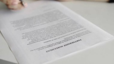 İş kadını ortaklık anlaşması imzalıyor. Belgeyi imzalayan kişi
