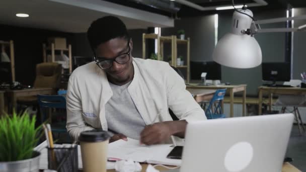 Unavený africký podnikatel pracující za stolem a vyhazující papír — Stock video