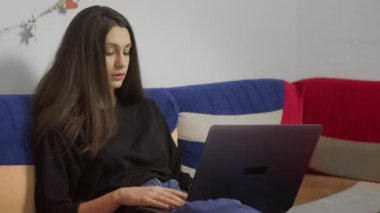 Dizüstü bilgisayarda, rahat koltukta oturan serbest çalışan bir genç. Evde dizüstü bilgisayarla çalışan serbest çalışan kadın blogcu. Blogger Gazetecisi Uzaktan Çalışıyor.