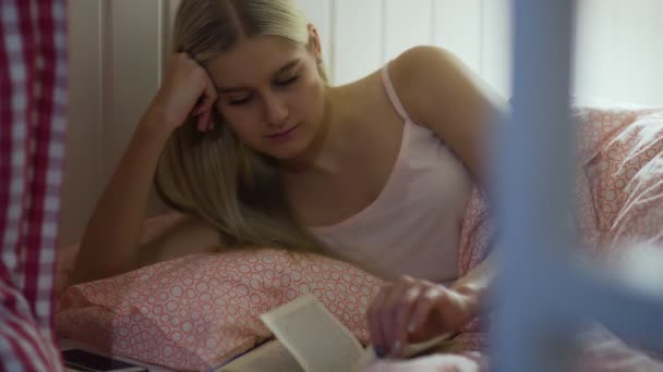 Jovem mulher lendo um livro na acolhedora sala de estar — Vídeo de Stock